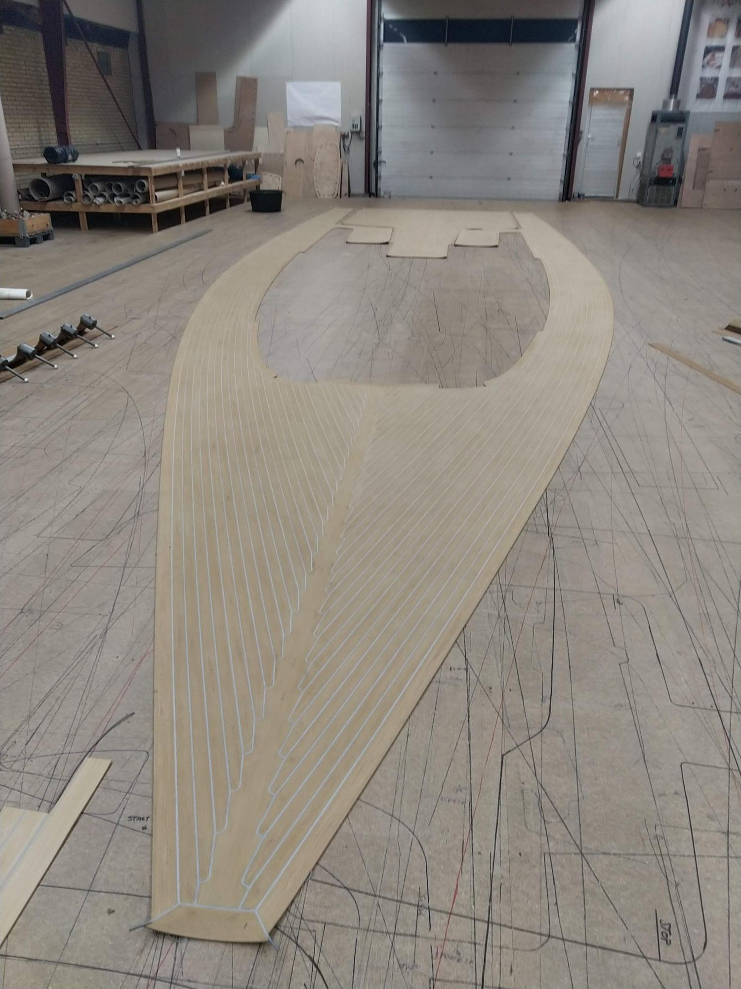 This image shows a boat deck covered with an imitation teak coating under construction